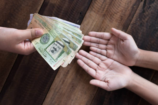 istock High Angle View Of Hands With Money Over Wooden Table 923776414