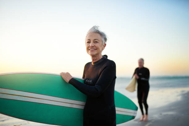 Dreams are made of sun, surf and sand Cropped shot of a senior married couple going surfing common couple men outdoors stock pictures, royalty-free photos & images