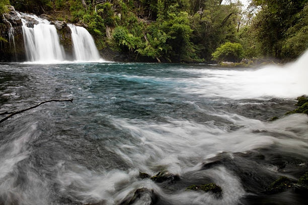 young man jump into the water of the clean river on the waterfall, swims, enjoys spending time on summer holidays. High quality photo