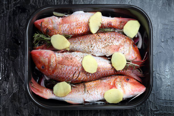 Raw red mullet with rosemary and ginger before baking