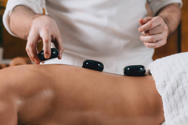 massage aux pierres chaudes - massaging spa treatment stone massage therapist photos et images de collection