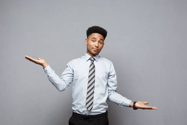 istock Business Concept - Confident thoughtful young African American showing balancing hands on side over grey background. 923792106