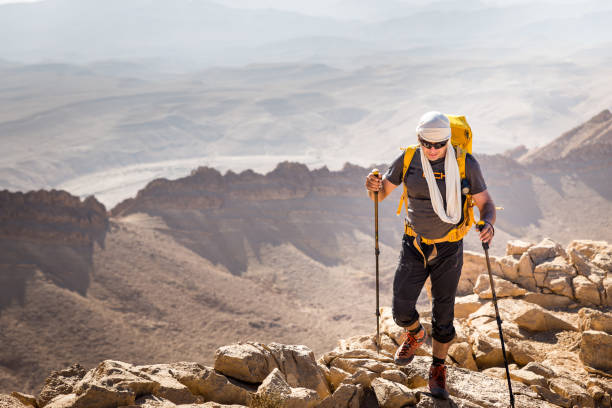 istock Tourist guide backpacker walking running mountain cliff desert, Israel. 923792152