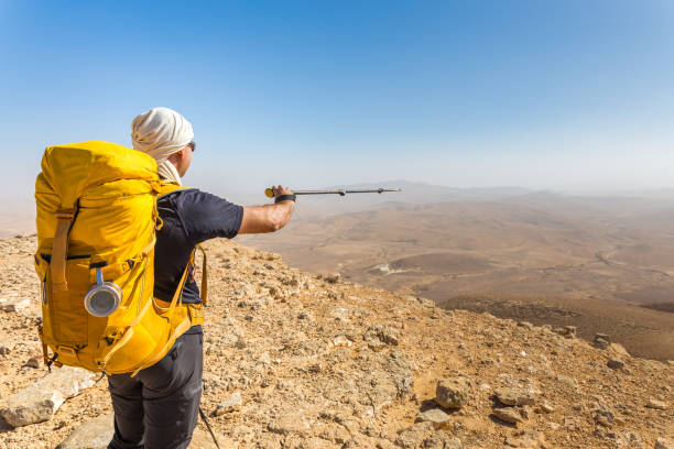istock Tourist guide backpacker pointing showing directions desert mountains, Israel. 923792528