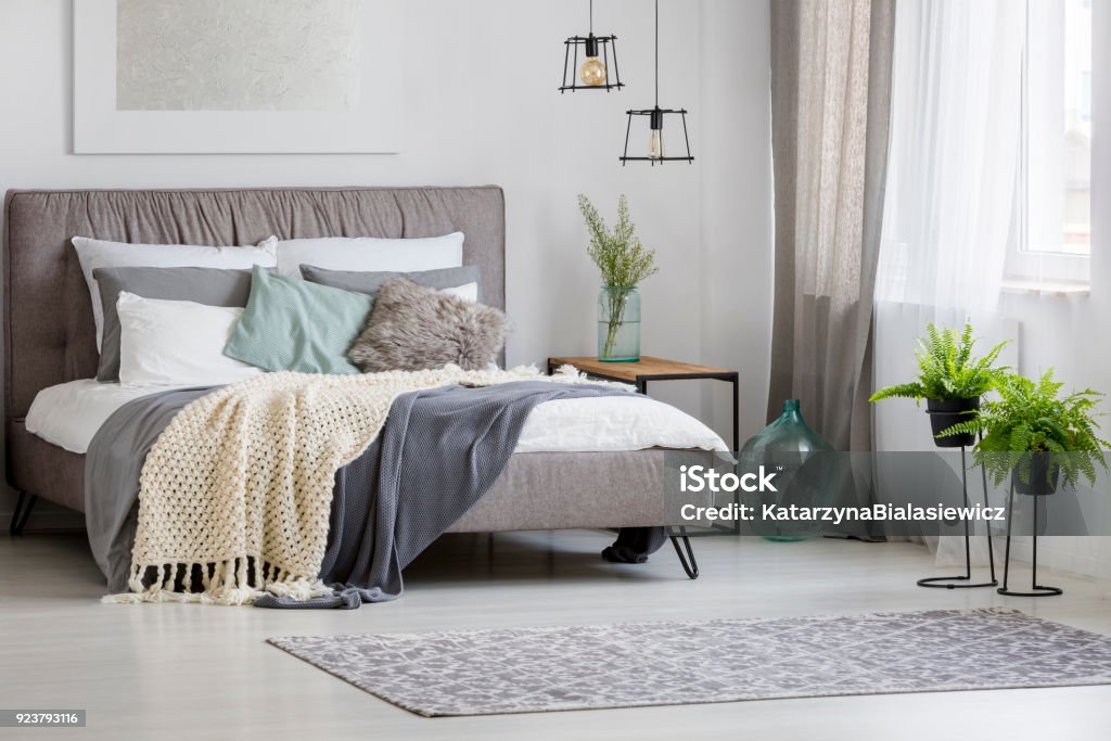 Modern bedroom interior Grey, modern bedroom interior with king-size bed decorated with cushions and blankets Bedroom Stock Photo