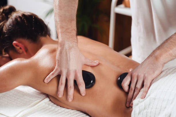 massage aux pierres chaudes - massaging spa treatment stone massage therapist photos et images de collection