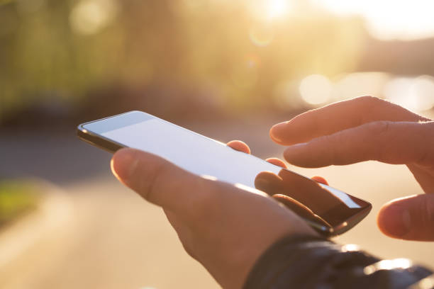 man using his mobile phone outdoor - smart phone text messaging mobile phone telephone imagens e fotografias de stock