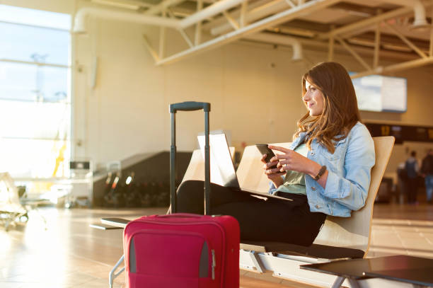 istock Young female passenger using smartphone and laptop 923796040