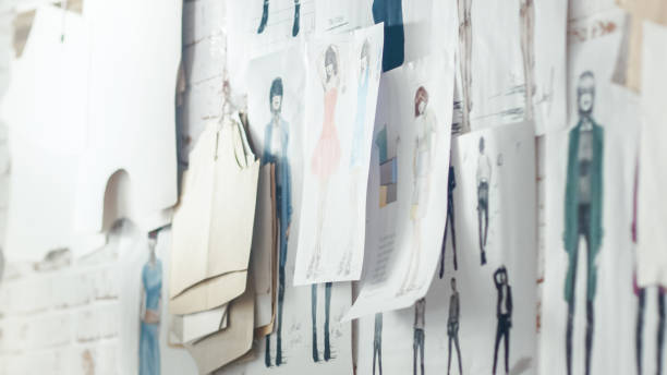 Wall with Pinned Fashion Drawings and Sketches, Templates Hanging on the Wall. Wall with Pinned Fashion Drawings and Sketches, Templates Hanging on the Wall. clothing design studio photos stock pictures, royalty-free photos & images