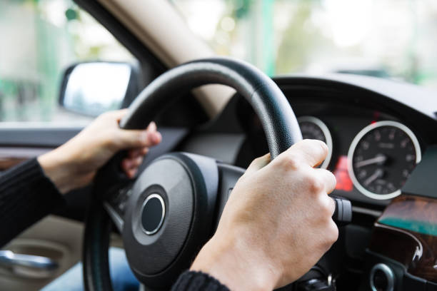 istock Close up of man hands driving a car during sunlight 923796566
