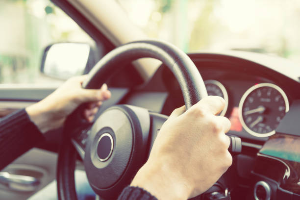 istock Close up of man hands driving a car during sunlight 923796780