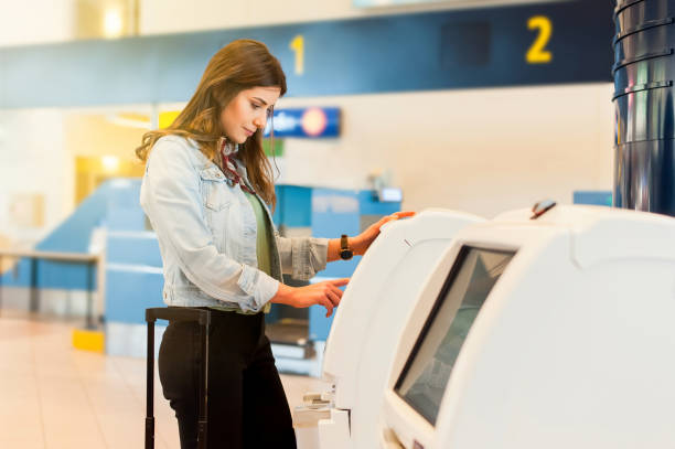 young travel woman in the airport using atm machine - airport check in counter imagens e fotografias de stock