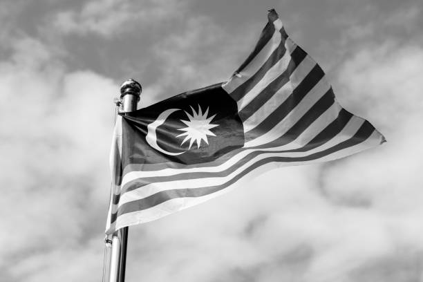 Malaysia flag also known as Jalur Gemilang wave with the blue sky. People fly the flag in conjunction with the Independence Day celebration or Merdeka Day. stock photo