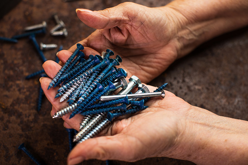 Senior woman hands selecting screws