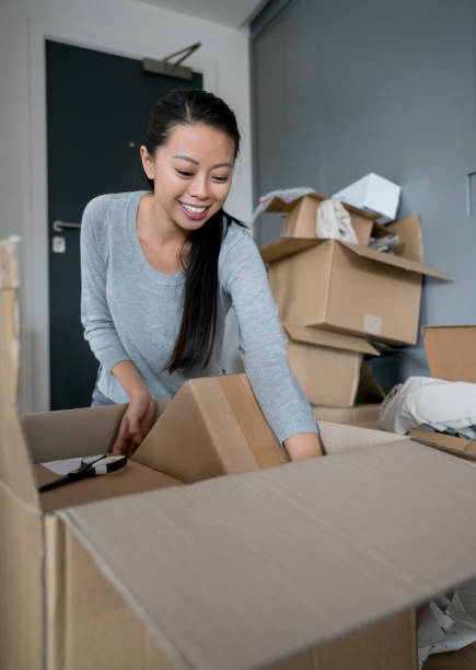istock Asian woman unpacking while moving house 923805996