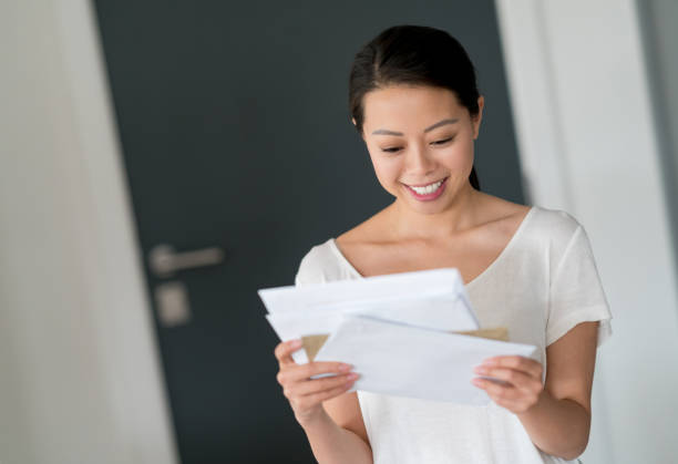 istock Asian woman at home checking her mail 923806002