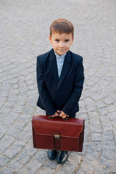 istock Smiling future businessman in formal costume with briefcase 923806440