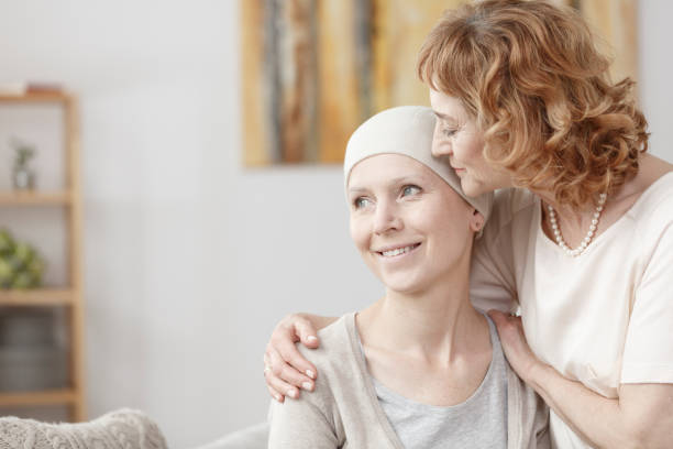 Mother hugging her daughter Mother hugging her adult daughter with cancer during home visit bare bosom pic stock pictures, royalty-free photos & images