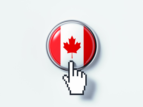 Hand shaped computer cursor is clicking on a push button on white surface. The button is textured with Canadian flag. Horizontal composition with copy space and clipping path.