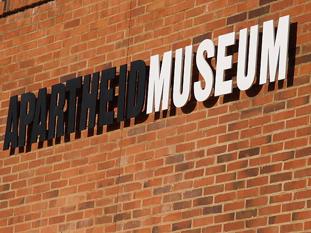 Black and white sign reading Apartheid Museum on brick 