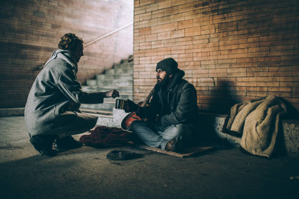 istock Lady helping homeless man 923821218