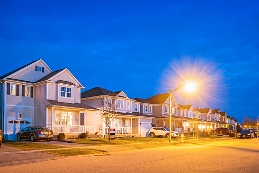 Stock photograph of a row of new homes in Brantford Ontario Canada, illuminated at twilight blue hour.