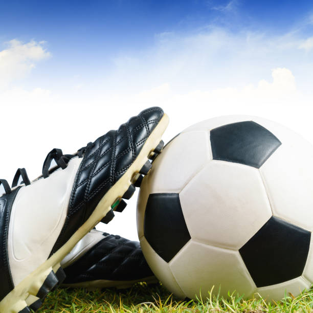 istock Soccer ball and shoes on grass 923824454
