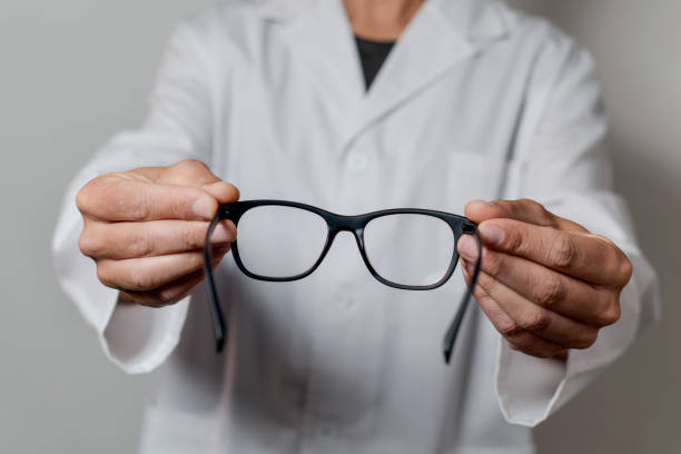 istock optician man bringing a pair of eyeglasses 923827818