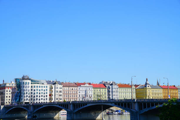 Colorful European architecture with landmark Dancing House building across Vltava River and bridge under clear blue sky Prague Czech Republic August 31 2017