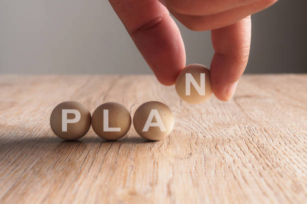 istock Hand putting on plan word written in wooden ball 923831922