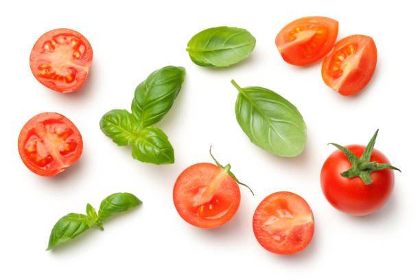 tomaten und basilikum-blätter, isolated on white background - cherry tomato image raw colors stock-fotos und bilder