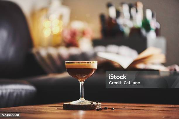 Espresso Martini Cocktail In Indoor Setting With Coffee Beans And Book On Coffee Table Stock Photo - Download Image Now