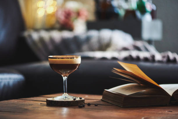 istock Espresso martini cocktail in indoor setting with coffee beans and book on coffee table 923846958