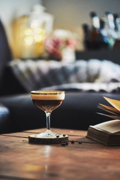 istock Espresso martini cocktail in indoor setting with coffee beans and book on coffee table 923847440