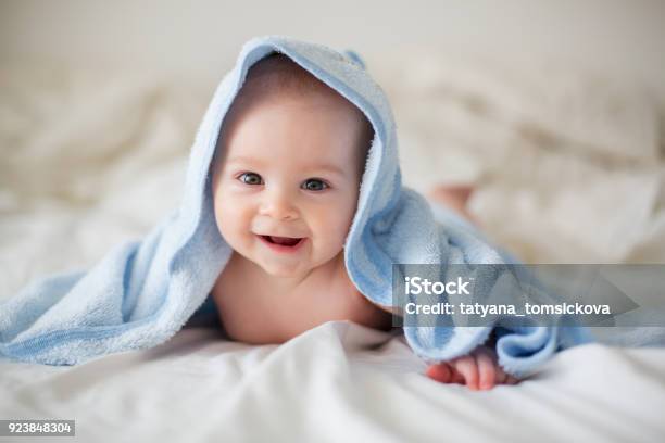 Lindo Bebé Niño Relajante En La Cama Después Del Baño Sonriendo Alegremente Foto de stock y más banco de imágenes de Bebé