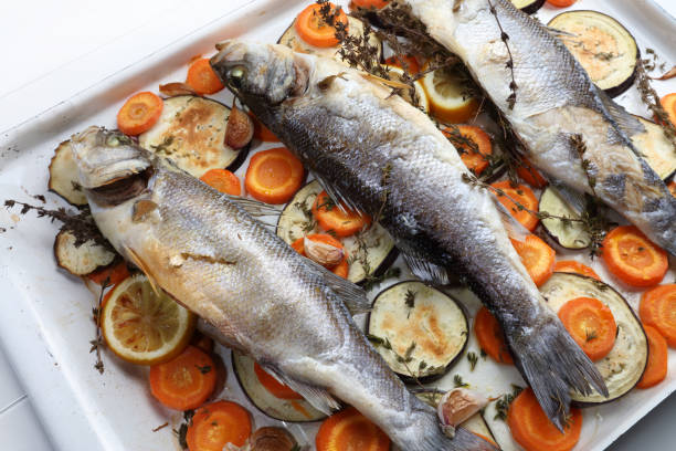 istock Whole baked seabass with lemon, thyme, carrots, garlic and eggplant 923848802