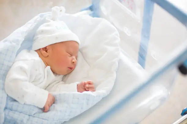Photo of Newborn baby laying in crib in prenatal hospital