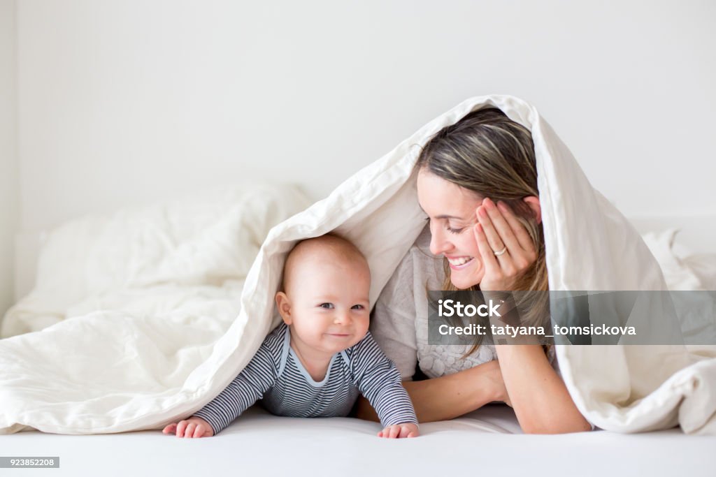 Mère et son petit garçon de bébé, jouer ensemble en bedrroom - Photo de Bébé libre de droits