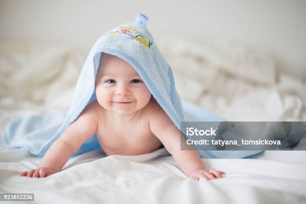 Cute Little Baby Boy Relaxing In Bed After Bath Smiling Happily Stock Photo - Download Image Now