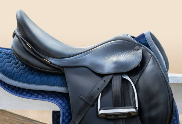 istock Black English saddle hanging on fence near stables. 923855574