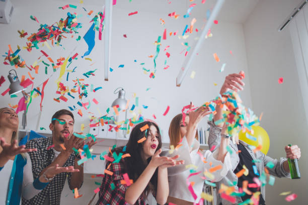 blowing confetti on party - birthday party adult women imagens e fotografias de stock