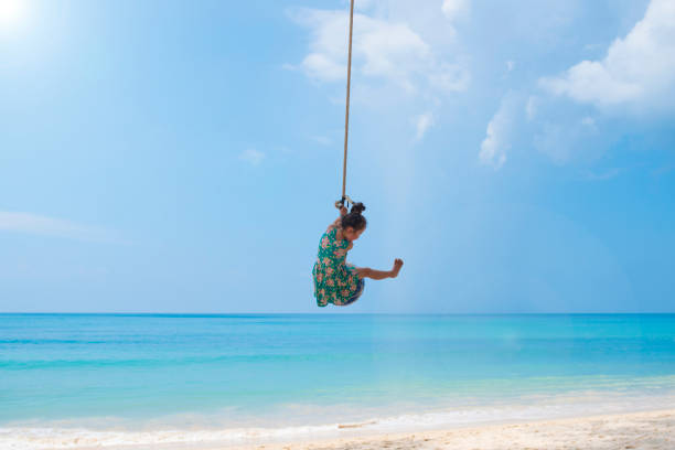 istock Little girl playing on the beach rope 923861506