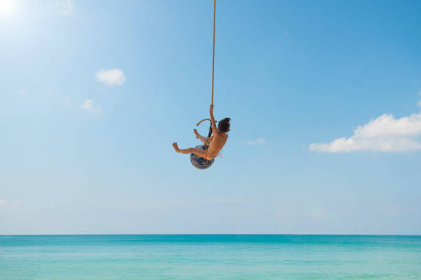 istock Little girl playing on the beach rope 923861824