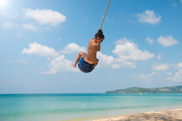 istock Little girl playing on the beach rope 923861890
