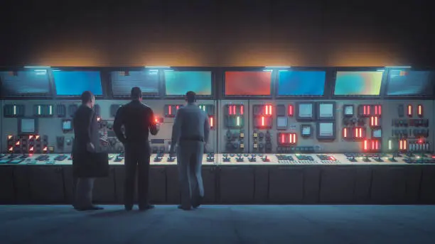 Retro underground control room with men in front of the console.