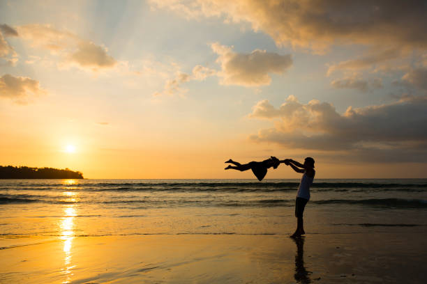 istock Father and daughter playing on the sunset beach 923862412