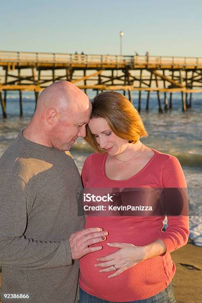 Young Pregnant Couple Looking Down Stock Photo - Download Image Now - Adult, Beach, California