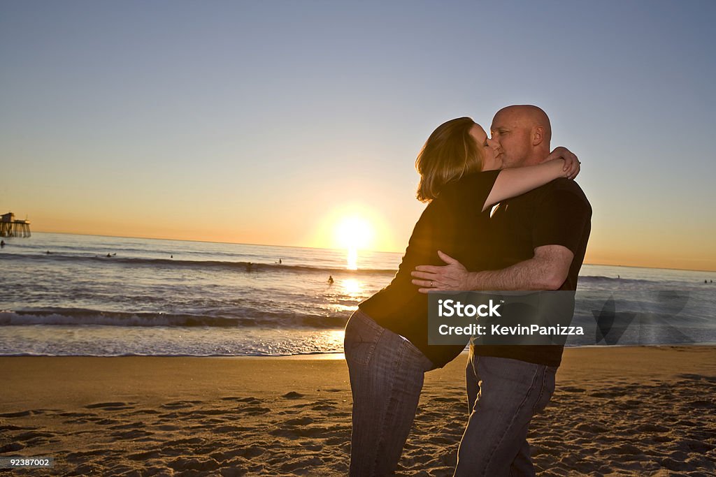 Grávida Casal na praia ao pôr-do-sol - Foto de stock de Abdômen Humano royalty-free
