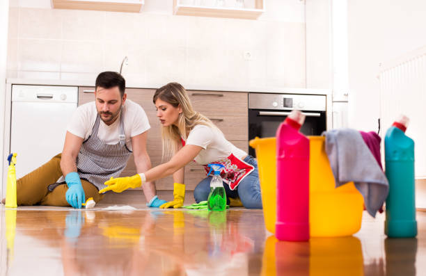 istock Young couple cleaning kitchen floor together 923872978