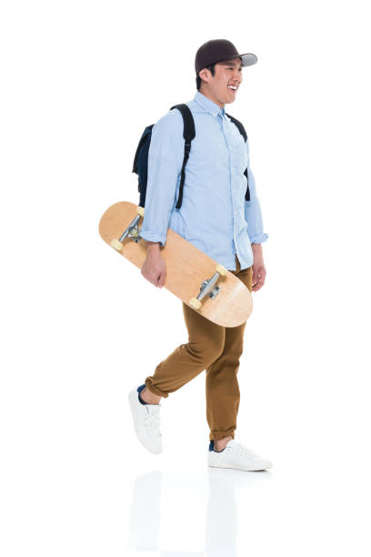 istock Happy Korean Male Student Walking With Skateboard 923875826